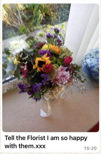 A vibrant bouquet of mixed flowers in various colours arranged on a table.